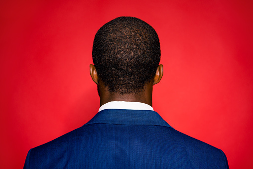 Back view of young chic classy brunet sophisticated style man stand isolated on red vivid background