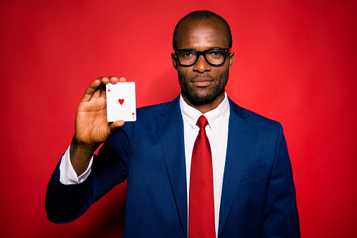 Portrait of classy ethnicity multiethnic calm analyst sale manager occupation agent man in formalwear style jacket stand isolated on red vivid background with card in hand