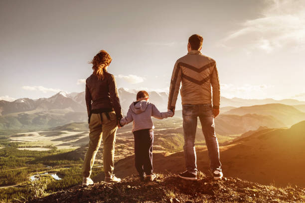 istock Family with son stands mountains sunset 1054247596