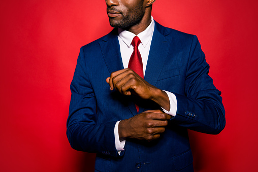 Cropped close up photo of sale manager entrepreneur chic employee employer occupation leadership gentleman groomed man correct cufflink fasten clasp on wrist isolated on red bright background