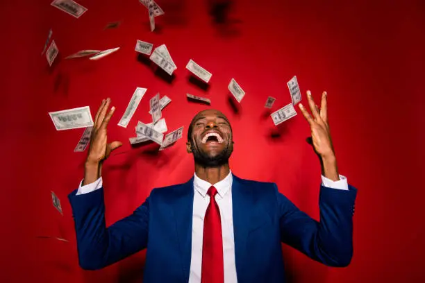 Photo of Attractive multiethnic man in style chic classy jacket blue formalwear  trendy tux tuxedo stand with closed eyes under money fly rain isolated on red vivid background raised hands up