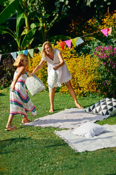 istock Mother and daughter spreading picnic blanket 1054256710