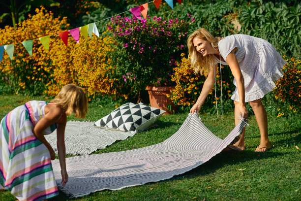 istock Mother and daughter spreading picnic blanket 1054256720