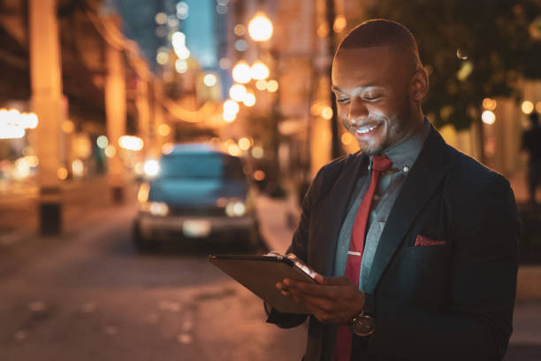 istock Chicago Streets at Night Smiling Businessman with Tablet Computer 1054272876