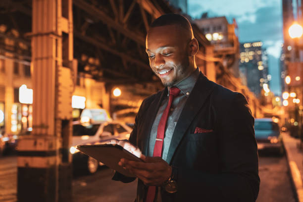 homme d’affaires tablet pc dans les rues de chicago dans la nuit - standing digital tablet adult beautiful photos et images de collection