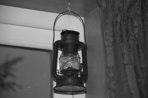 Image of an old fashioned, oil-powered hurricane lamp in a doorway.