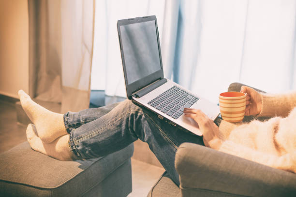 istock Young woman using laptop. Female hands using touchpad, keyboard while sitting in an armchair 1054292448