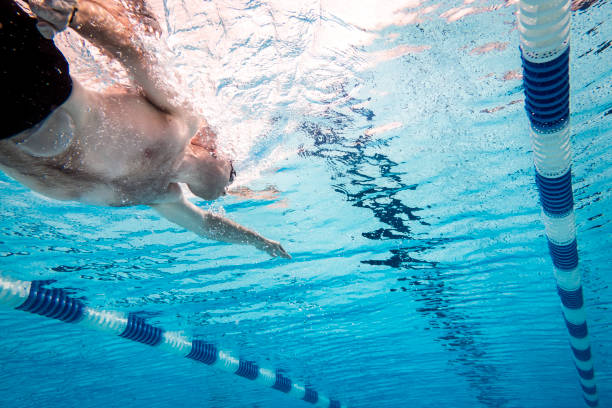 mann mit stoma beutel schwimmen unter wasser im pool - stomata stock-fotos und bilder