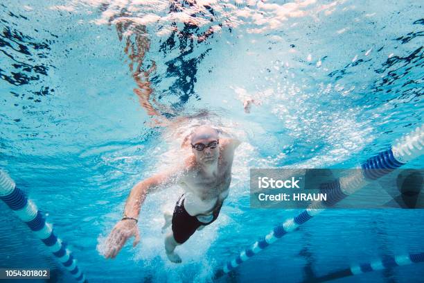 Sportsman With Stoma Bag Swimming Underwater Amidst Lane Markers Stock Photo - Download Image Now