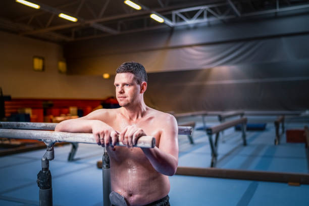 istock Male athlete with stoma bag is leaning on parallel bars at gym 1054306650