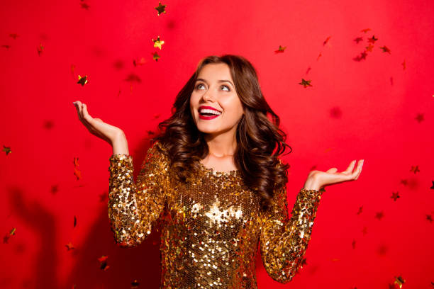 Look like fall stars from the sky! Lady with big white beaming smile look aside stand with modern wave hairdro isolated on vivid red background win winner