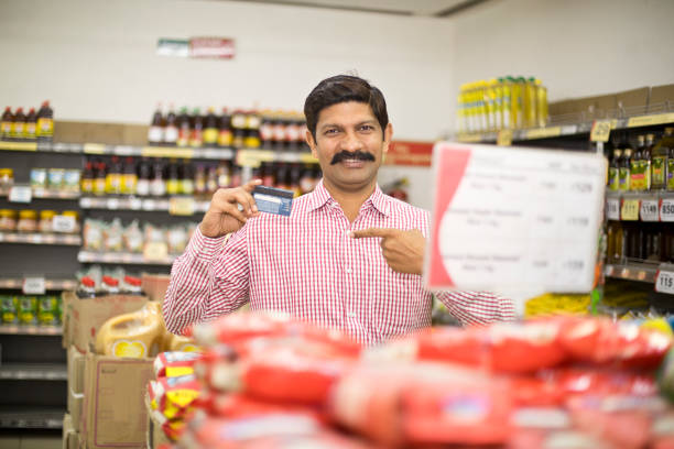 istock Man pointing at credit card in supermarket 1054317120
