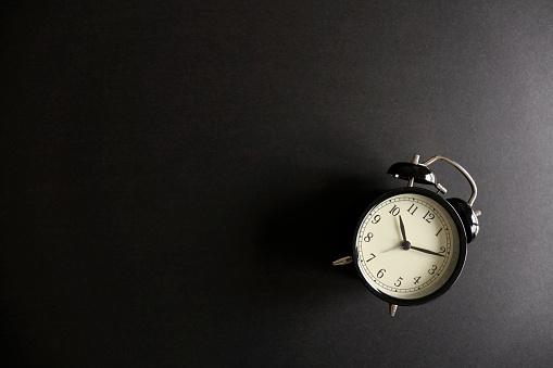 Black alarm clock on a black background