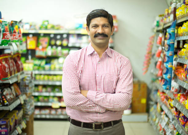 Man in grocery aisle of supermarket Man in grocery aisle of supermarket convenience store stock pictures, royalty-free photos & images