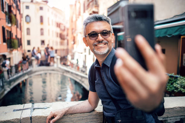 touristischen lächelnd während selfie aufnahme mit handy - men gondolier people activity stock-fotos und bilder