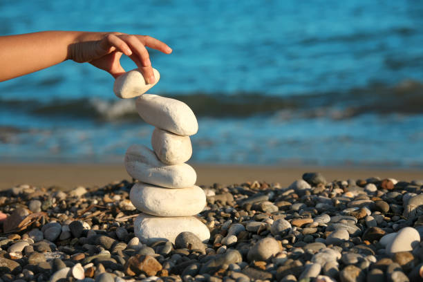 istock Close up young boy hand playing with stones on beach 1054326404