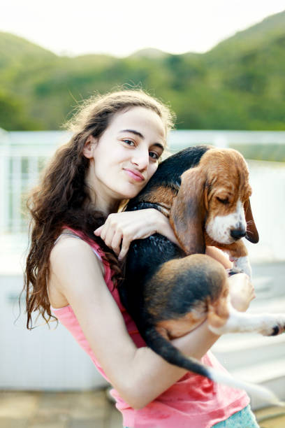 istock Young girl playing with the dog while giving him a bath 1054338322