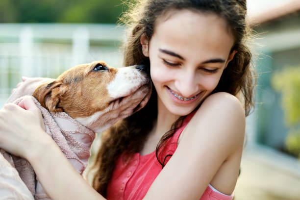 istock Young girl playing with the dog while giving him a bath 1054338378