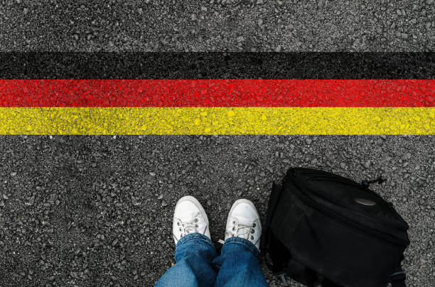 istock a man with a shoes standing next to German flag 1054348494