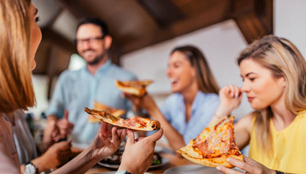 istock Close-up image of friends eating pizza. 1054348500