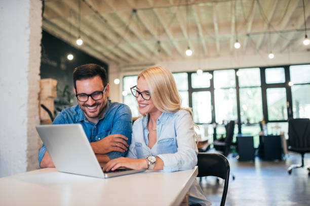 istock Two smiling coworkers working in a modern office. 1054349672