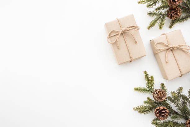 istock Gift boxes with pine branches and pine cones are on top of white desk table during Christmas or new year. Top view with copy space, flat lay. 1054350068