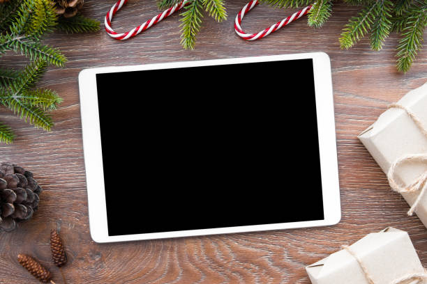 istock Christmas background with table that has blank mockup screen for montaging the application. Top view, flat lay. 1054350104