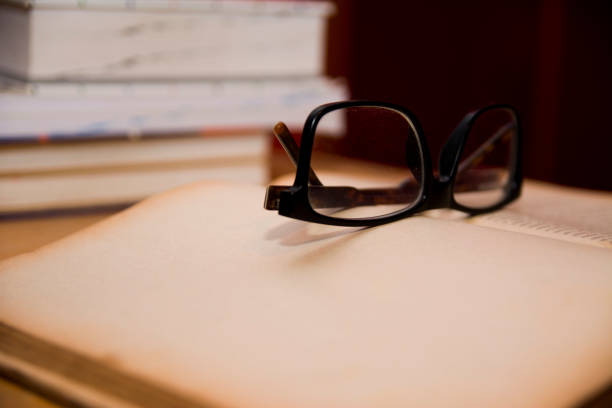 istock Book and Reading Glasses on wooden table 1054361830