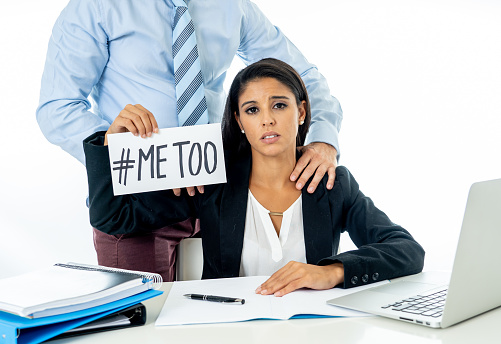 Me Too Harassment Campaign. Young businesswoman being sexually harass by her boss in the office holding a note with the text me too in stop sexual abuse women human rights concept.