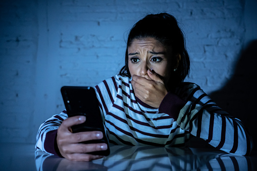 Miedo adolescente o mujer joven con teléfono celular móvil inteligente como ciberbullying internet por mensaje peciolada abusado a víctima. photo
