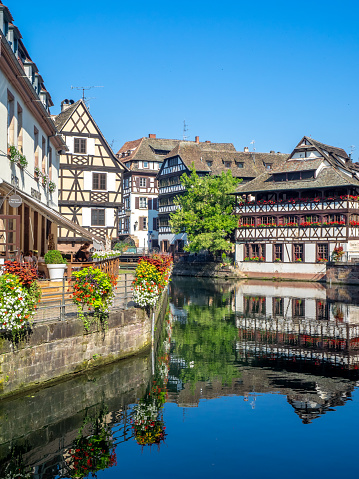 Strasbourg, France - July 25, 2018: Beautiful views along the Ill River in Petite France areas of Strasbourg in the Alsace region of France. The homes are the traditional half timbered houses visible.
