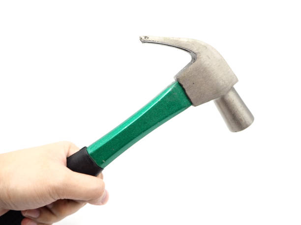 istock Hand holding a green iron hammer with rubberized handle isolated on a white background. 1054366802