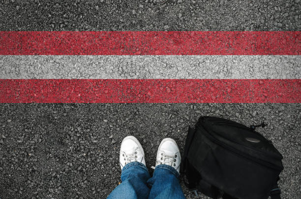 istock a man with a shoes standing  next to Austrian flag 1054368818