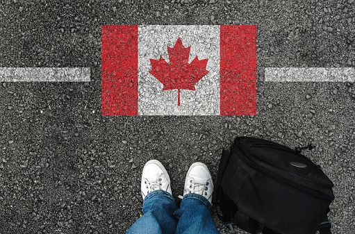 un hombre con un calzado está próxima a la bandera de Canadá photo