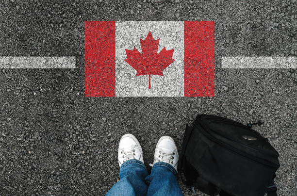 человек в обуви стоит рядом с флагом канады - canada стоковые фото и изображения