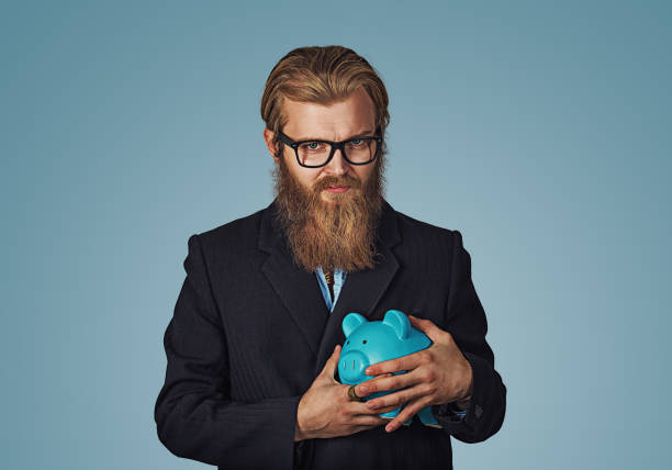 young greedy stingy business man holding piggy bank - cheep imagens e fotografias de stock