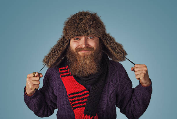 man holding showing fluffy fur hat in red scarf purple sweater stock photo