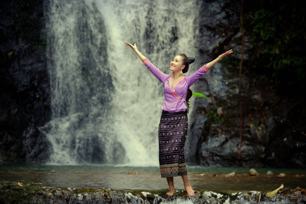 istock Woman With Arms Raised Against River 1054392136