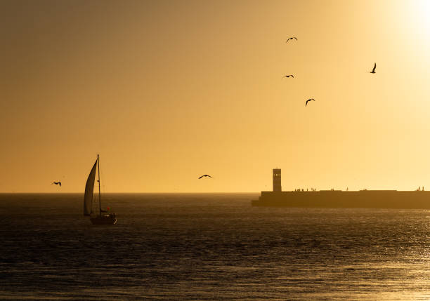 istock Sailboat Approaches Farol do Pontao at Dusk 1054399142