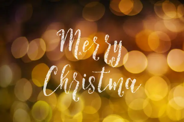 Photo of Merry Christmas and New Year typographical on pink gold sparkle bokeh or defocus  with Xmas card text.
