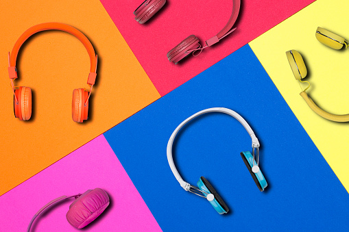Multicolored headphones on colorful paper background.
Colorful headphones music accessory studio design.