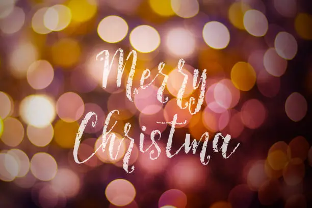 Photo of Merry Christmas and New Year typographical on pink gold sparkle bokeh or defocus  with Xmas card text.