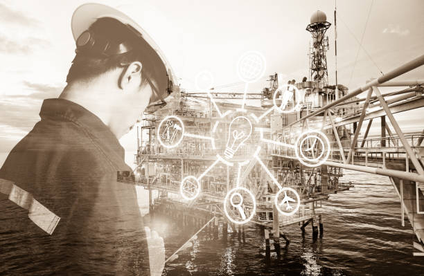 istock Double exposure of Engineer or Technician man with digital icon operated platform or plant by using tablet with offshore oil and gas platform background for industry business concept. 1054405280
