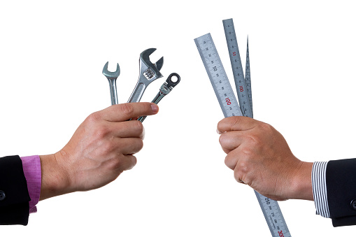 Two Mechanic engineers holding two ratchet box end wrench and open end wrench in his hand and other one holding ruler and scale; handing tool on white background with clipping path