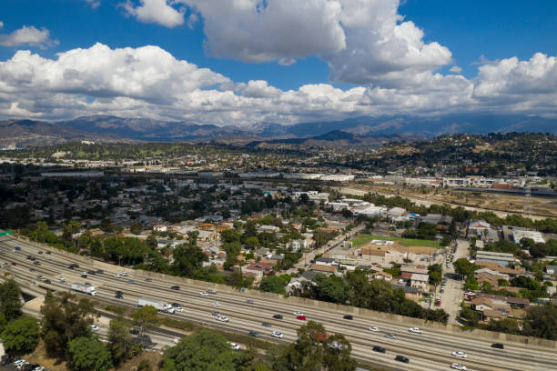 Urban Sprawl and 5 Freeway, Los Angeles - Drone Shot This shot is take from Echo Park neighborhood looking north with the 5 Freeway in the foreground below and the cities of Glassel Park, Cypress Park, Eagle Rock, Mount Washington, Glendal, La Canada and the Mountain range in the distance. The sky is filled with white puffly clouds. eagle rock stock pictures, royalty-free photos & images