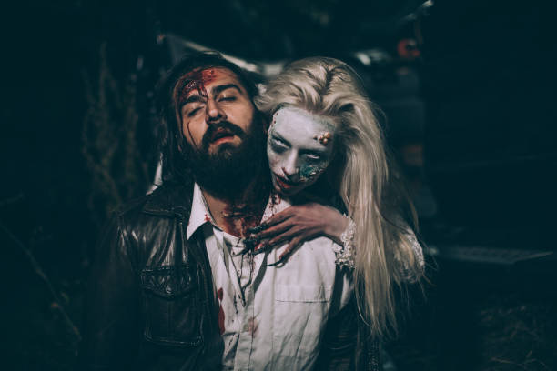 Witch attacked a man at night Man and woman, she masked herself in a scary witch for halloween, attacking a man. male vampire biting his victim stock pictures, royalty-free photos & images