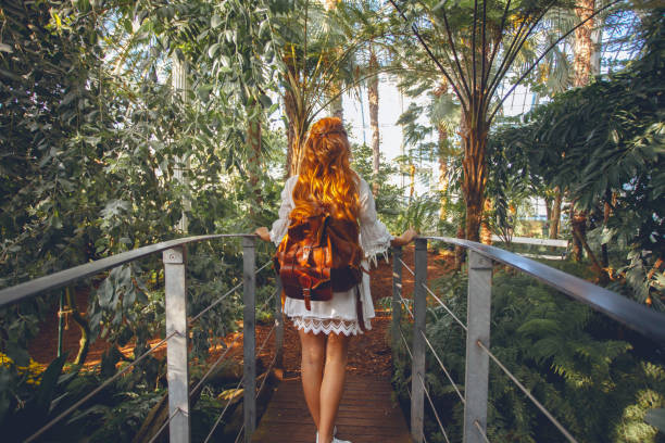 mujer joven en ambiente tropical - jardín botánico fotografías e imágenes de stock