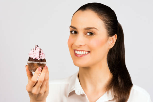 istock woman eating cupcake 1054418776