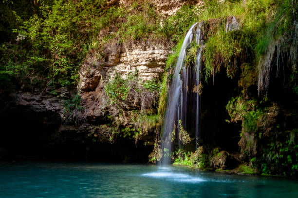 istock Waterfall and a beautiful lagoon lake for relaxing in the summer forest. 1054423090