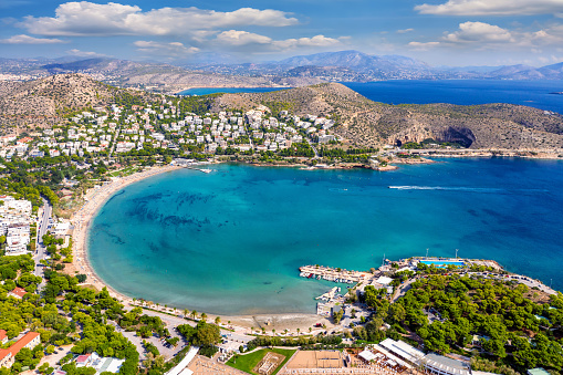 Aerial view of the picturesque Vouliagmeni beach on the south coast riviera of Athens, Greece, during summer time